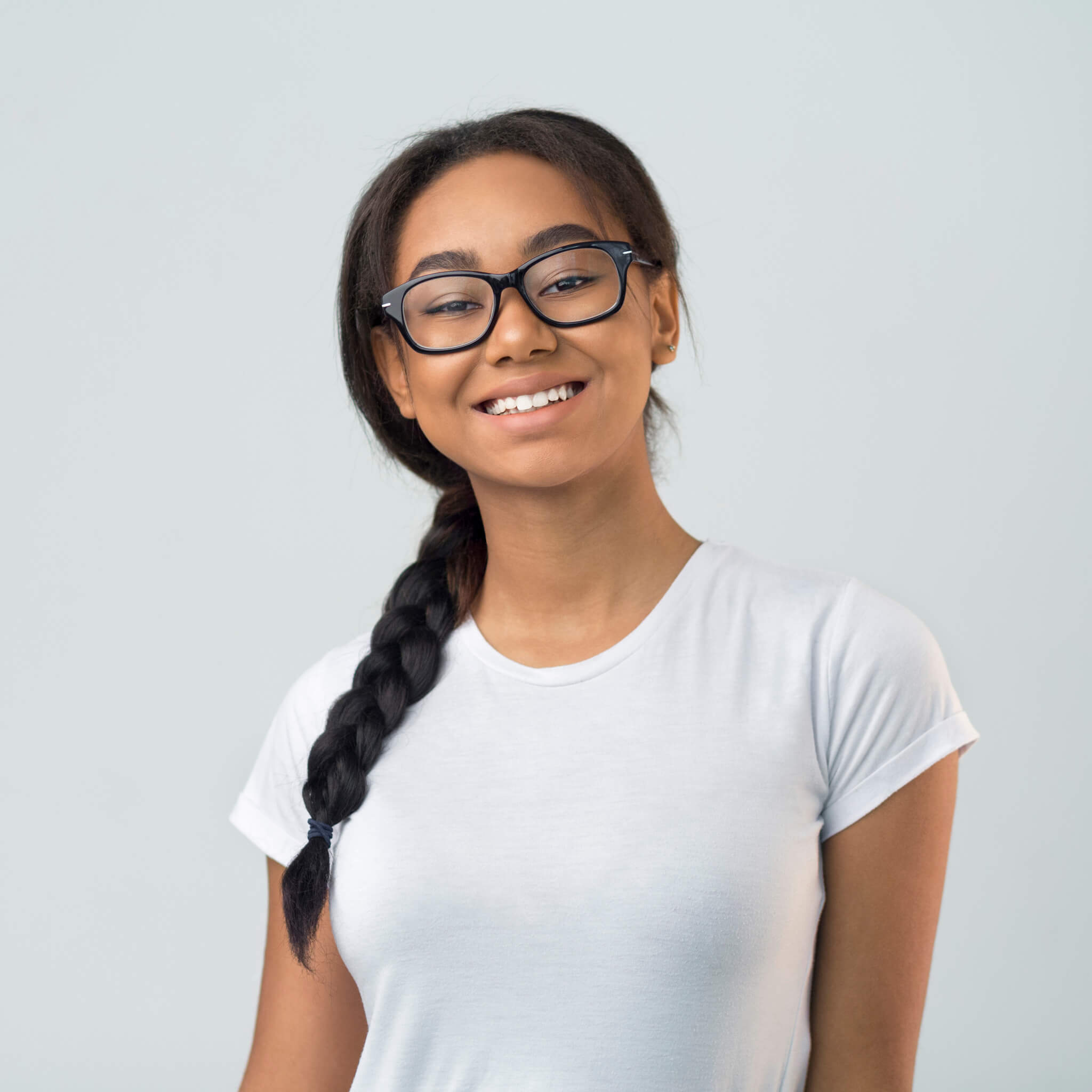 Smiling afro girl in eyeglasses posing over grey background