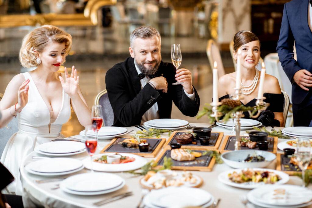 Elegantly dressed people having a festive dinner indoors
