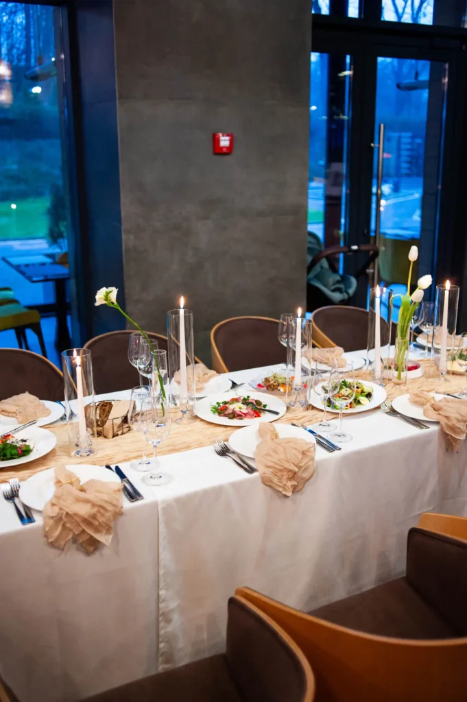 beautiful table setting with flowers and cutlery on wooden table at wedding or dinner