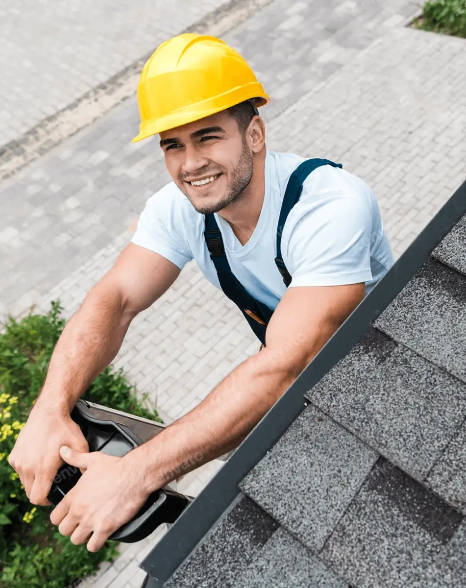 overhead view of happy man in yellow helmet smiling near roof small