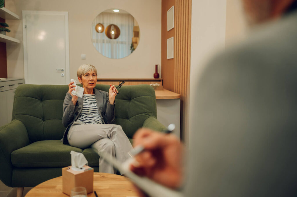 A senior female patient is having a session with a psychotherapist in a doctor's office