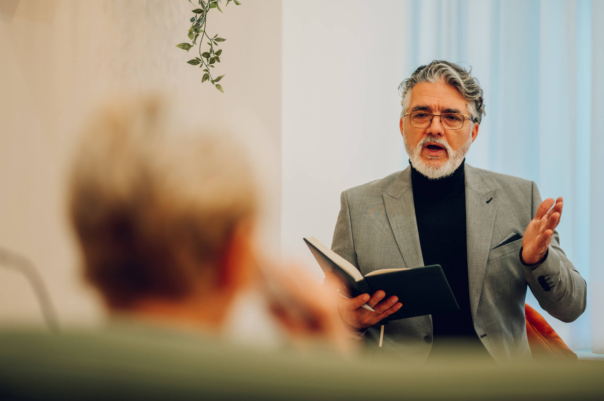 Man Talking While Reading A Book Indoors