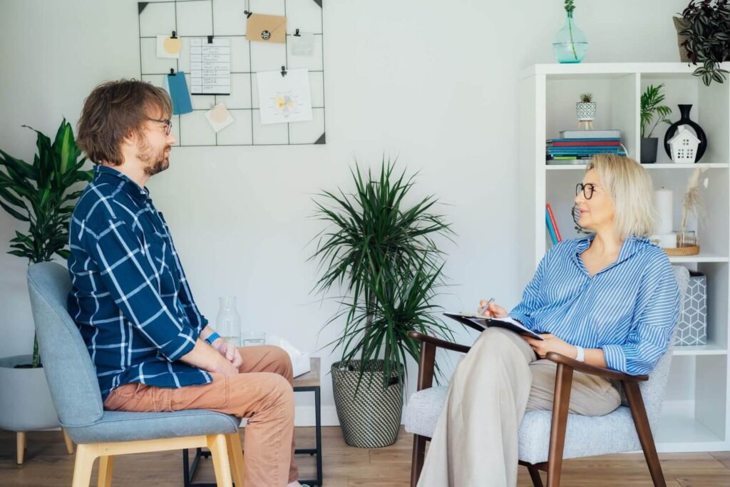 Professional psychotherapy. Female psychologist having session with male patient at clinic