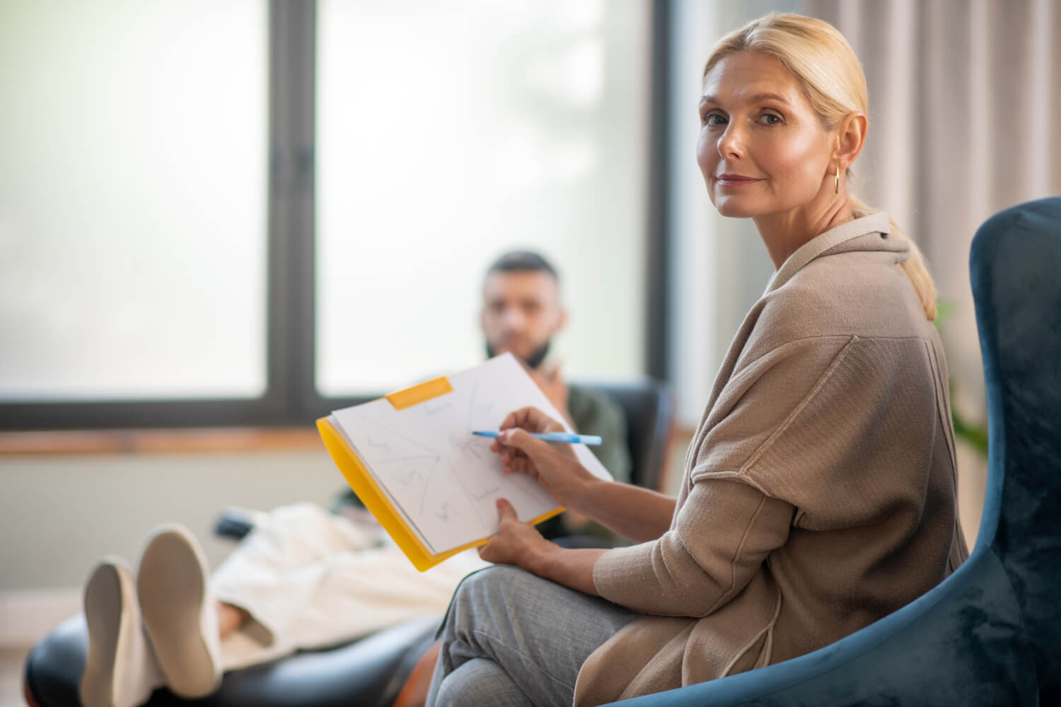 Woman Writes Notes While Man Relaxes on Couch